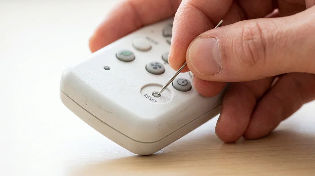 Réinitialisation d'une télécommande de climatiseur Fujitsu Pointe appuyant sur le bouton de réinitialisation de la télécommande Fujitsu