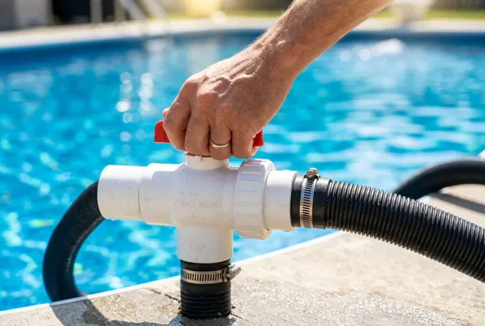 Réglage d'une vanne by-pass PVC reliée au tuyau noir de chauffage de piscine
